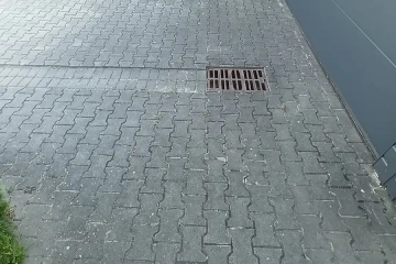 kostka brukowa przed czyszczeniem – zabrudzona nawierzchnia przy wejściu do budynku