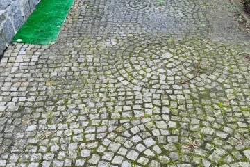 zabrudzona kostka granitowa na ścieżce – powierzchnia przed myciem ciśnieniowym